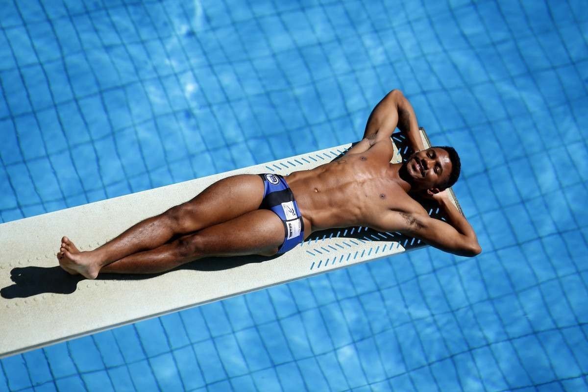 Isaac Souza posa para foto deitado no trampolim do Centro Olímpico da UnB, em Brasília