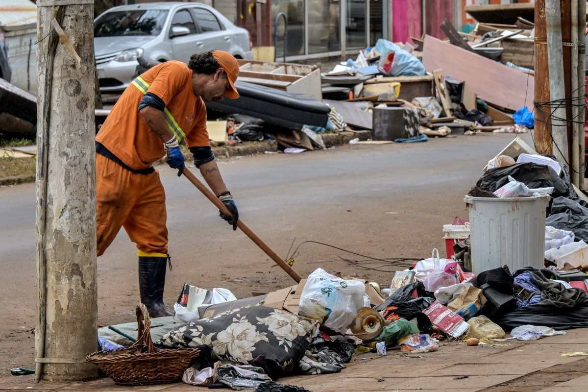 Trabalhadores removem lixo após as enchentes históricas em Porto Alegre, Brasil, em 20 de maio de 2024. 
