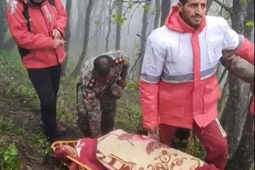 Esta captura tirada de um vídeo divulgado pelo Cescent Vermelho Iraniano em 20 de maio de 2024 mostra equipes de resgate recuperando corpos no local da queda do helicóptero do presidente Ebrahim Raisi, em uma área montanhosa envolta em neblina no noroeste do Irã.