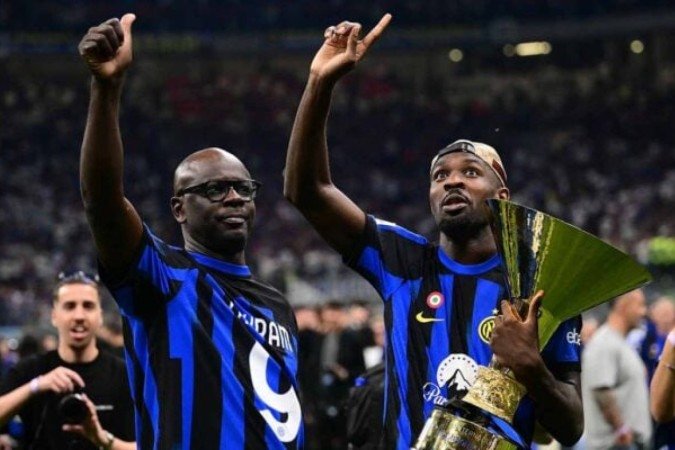 Marcus Thuram (esquerda) posa para foto com o troféu de campeão da Itália com seu pai, Liliam Thuram (direita) -  (crédito: Foto: Marco Bertorello/AFP via Getty Images)