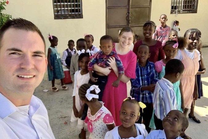 Os missionários norte-americanos Davy e Natalie Lloyd posando com crianças haitianas -  (crédito: MISSIONS IN HAITI / AFP)