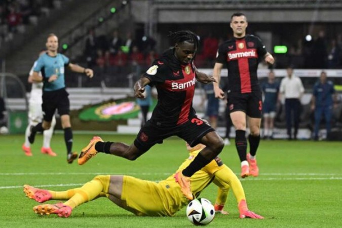  Bayer Leverkusen's Dutch defender #30 Jeremie Frimpong gets past Kaiserslautern's German goalkeeper #18 Julian Krahl during the German Cup (DFB-Pokal) final football match between 1 FC Kaiserslautern and Bayer 04 Leverkusen at the Olympic Stadium in Berlin on May 25, 2024. (Photo by JOHN MACDOUGALL / AFP) / DFB REGULATIONS PROHIBIT ANY USE OF PHOTOGRAPHS AS IMAGE SEQUENCES AND QUASI-VIDEO. (Photo by JOHN MACDOUGALL/AFP via Getty Images)
     -  (crédito:  AFP via Getty Images)