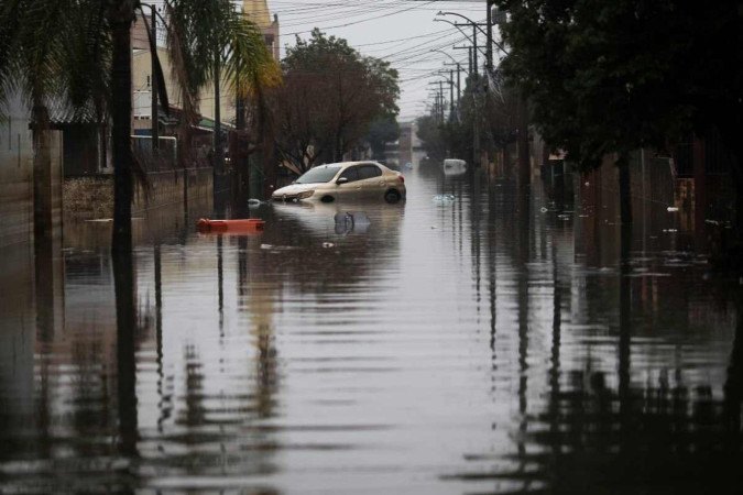  A car is partially submerged in a flooded street in the Sarandi neighborhood, one of the hardest hit by the heavy rains in Porto Alegre, Rio Grande do Sul state, Brazil, on May 27, 2024. Cities and rural areas alike in Rio Grande do Sul have been hit for weeks by an unprecedented climate disaster of torrential rains and deadly flooding. More than half a million people have fled their homes, and authorities have been unable to fully assess the extent of the damage. (Photo by Anselmo Cunha / AFP)
      Caption  -  (crédito:  ANSELMO CUNHA/AFP)