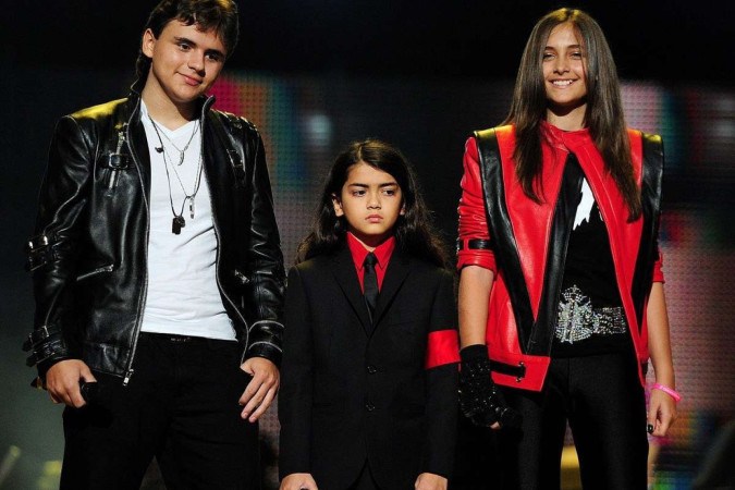 Na image, os filhos de Michael Jackson, Prince Jackson (E), Blanket Jackson (C) e Paris Jackson (D) em 2011 durante show em homenagem ao pai
 -  (crédito: LEON NEAL/AFP)