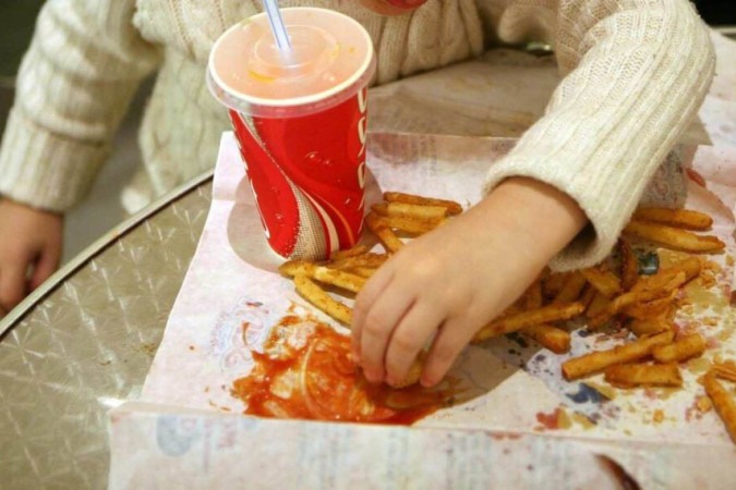  Criança comendo junk food. -  (crédito:  AFP)