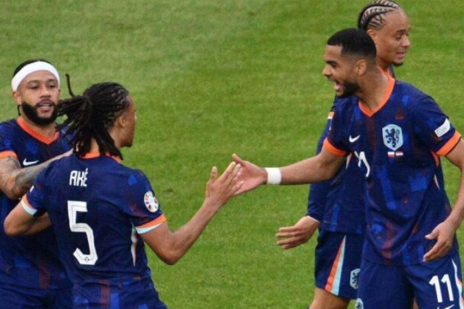 Gakpo (à direita, camisa 11) comemora  o seu gol com Aké (5), que deu o passe para o companheiro marcar o primeiro gol  da Holanda -  (crédito: Foto: Christophe SIMON/ AFP via Getty Images)