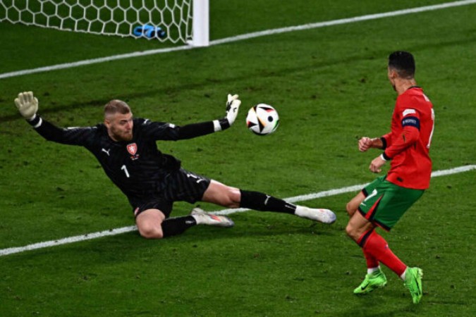  Czech Republic's goalkeeper #01 Jindrich Stanek (L) saves the ball shot by Portugal's forward #07 Cristiano Ronaldo during the UEFA Euro 2024 Group F football match between Portugal and the Czech Republic at the Leipzig Stadium in Leipzig on June 18, 2024. (Photo by GABRIEL BOUYS / AFP)
     -  (crédito:  AFP via Getty Images)
