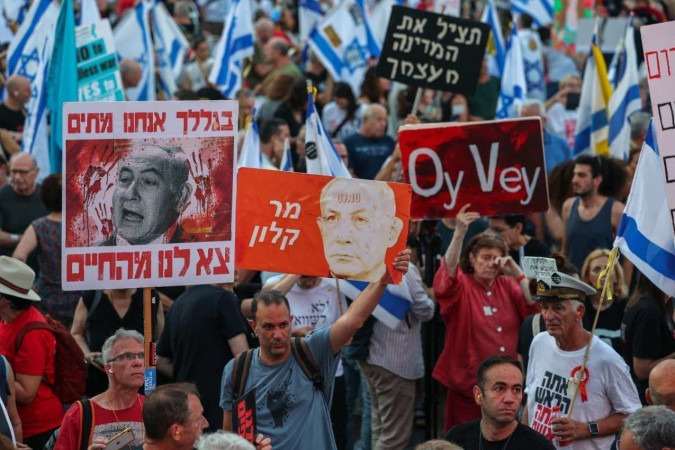  Left-wing activists lift placards and national flags during an anti-government demonstration in the Israeli coastal city of Tel Aviv on June 22, 2024, amid the ongoing conflict in the Gaza Strip between Israel and the Palestinian militant Hamas movement. (Photo by JACK GUEZ / AFP)
       -  (crédito: JACK GUEZ / AFP)