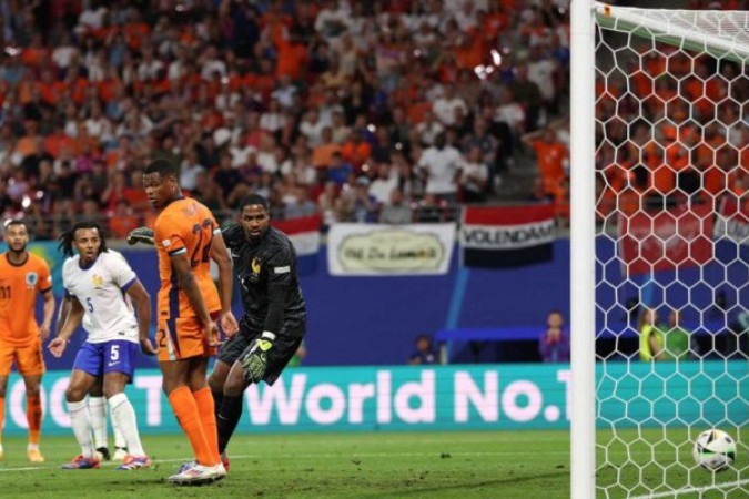 Goleiro Mike Maignan observa a bola após ser atrapalhado por Dumfries -  (crédito: Foto: Adrian Dennis/AFP via Getty Images)