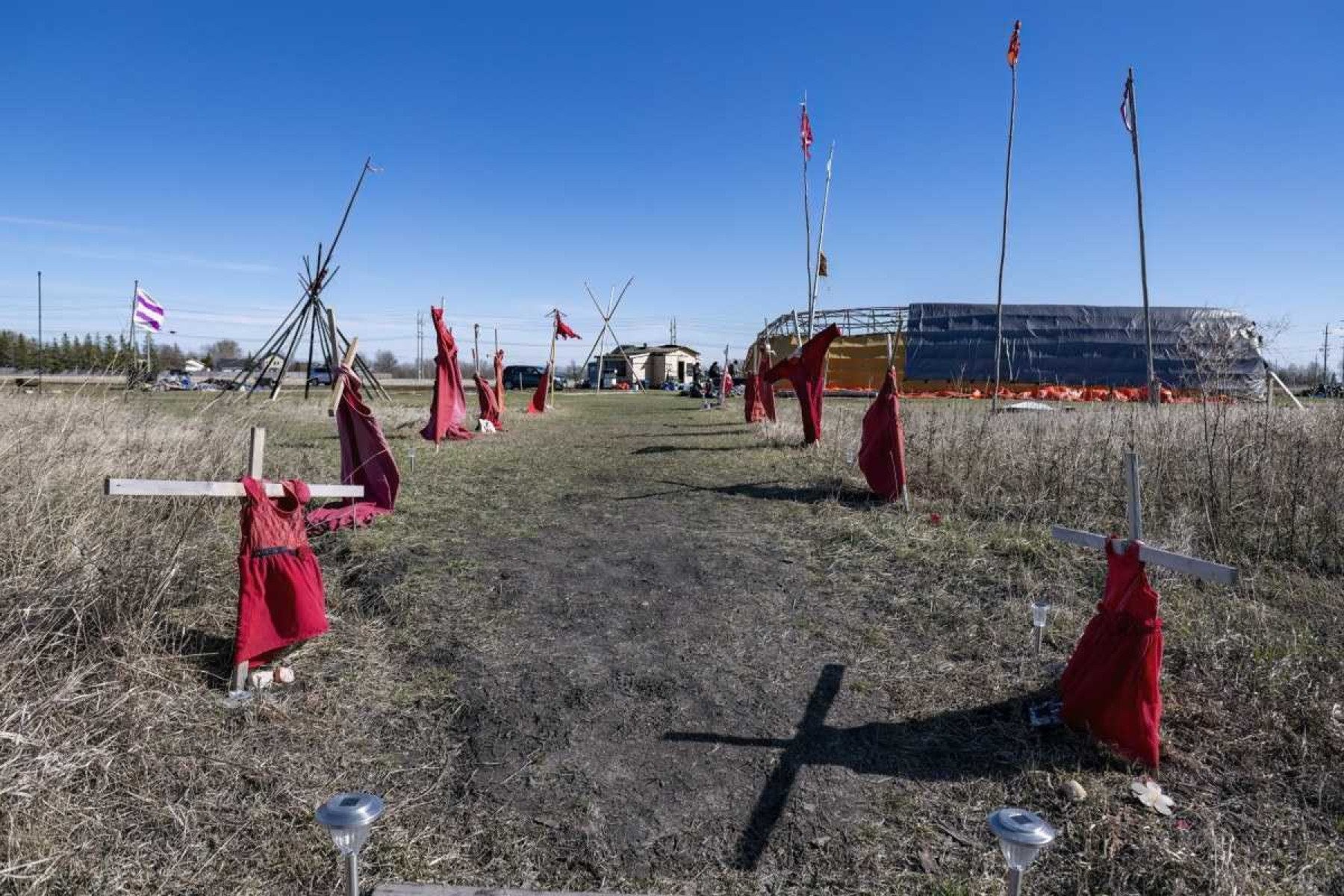  Red dresses on crosses are displayed at the entrance of a makeshift camp near near the Prairie Green landfill in Winnipeg, Manitoba, Canada, on April 27, 2024. The camp set up by the family of slained Morgan Harris take turns staying in the camp, seeking, says Morgan's daughter Elle Harris, 