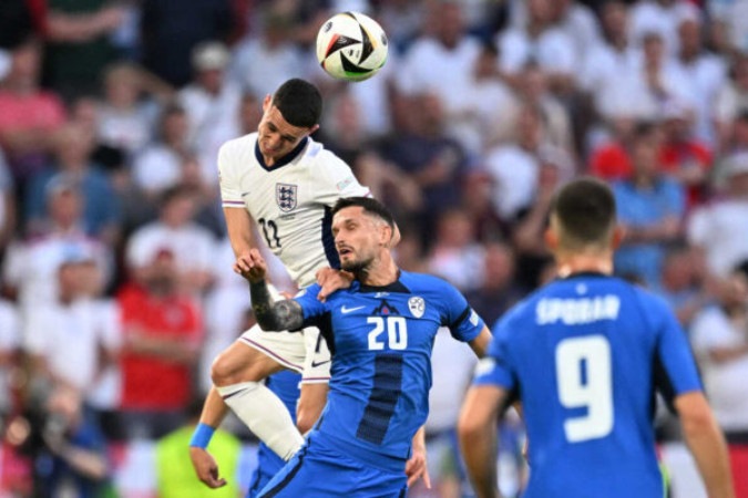  England's midfielder #11 Phil Foden (L) and Slovenia's defender #20 Petar Stojanovic (C) fight for the ball during the UEFA Euro 2024 Group C football match between England and Slovenia at the Cologne Stadium in Cologne on June 25, 2024. (Photo by Kirill KUDRYAVTSEV / AFP)
     -  (crédito:  AFP via Getty Images)
