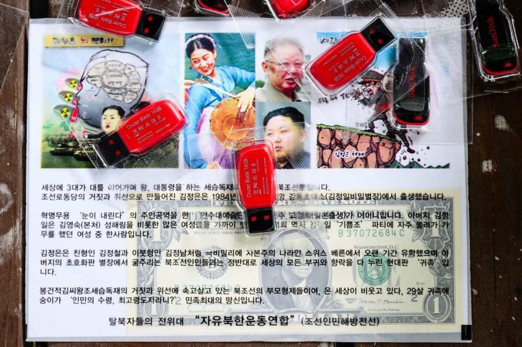     Um folheto contendo uma nota de dólar americano, em drives USB de K-pop, é visto durante uma entrevista da AFP com o desertor norte-coreano Park Sang-hak em Seul, em 25 de junho de 2024. Park considera os balões de propaganda que ele faz flutuar em sua terra natal como sendo parte de uma tradição de guerra psicológica e promete continuar até a queda do regime de Kim Jong Un.  Filho de um agente duplo norte-coreano que fugiu do seu país em 1999, Park tem enviado balões carregados com folhetos de propaganda anti-regime, notas de dólares americanos e unidades USB de K-pop através da fronteira há quase 20 anos.  (Foto de Anthony WALLACE / AFP) / Para acompanhar 'SKOREA-NKOREA-DIPLOMACY-CONFLICT, PROFILE' de Kang Jin-kyu e Cat Barton Legenda 