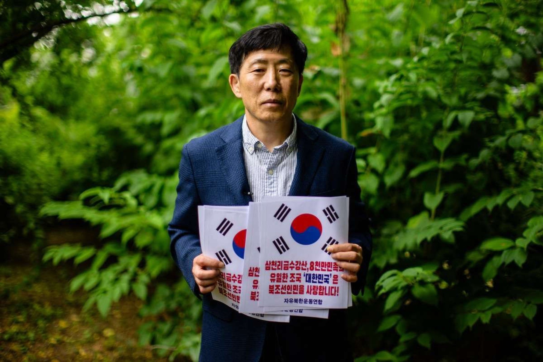  North Korean defector Park Sang-hak poses with a poster that reads 