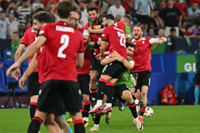  Georgia's players celebrate after winning the UEFA Euro 2024 Group F football match between Georgia and Portugal at the Arena AufSchalke in Gelsenkirchen on June 26, 2024. (Photo by OZAN KOSE / AFP)
     -  (crédito:  AFP via Getty Images)