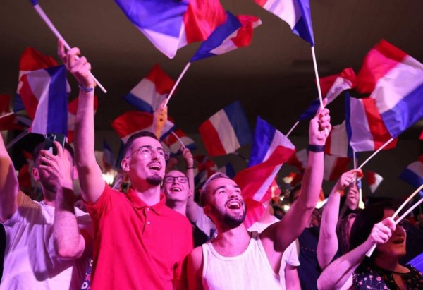 os Apoiadores hasteiam bandeiras francesas durante o discurso de Marine Le Pen -  (crédito: FRANCOIS LO PRESTI / AFP)