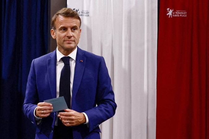 O presidente da França, Emmanuel Macron, sai da cabine de votação antes de votar no primeiro turno das eleições parlamentares em uma seção eleitoral em Le Touquet, norte da França, em 30 de junho de 2024 -  (crédito: Yara Nardi/POOL/AFP)