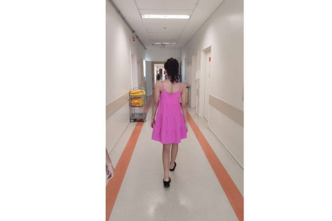 Bianca caminha pelo corredor do hospital após cirurgia para correção de escoliose