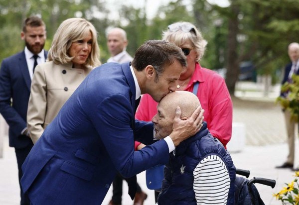 Presidente Emmanuel Macron beija a cabeça de simpatizante idoso, em Le Touquet, no norte -  (crédito: Yara Nardi/AFP)