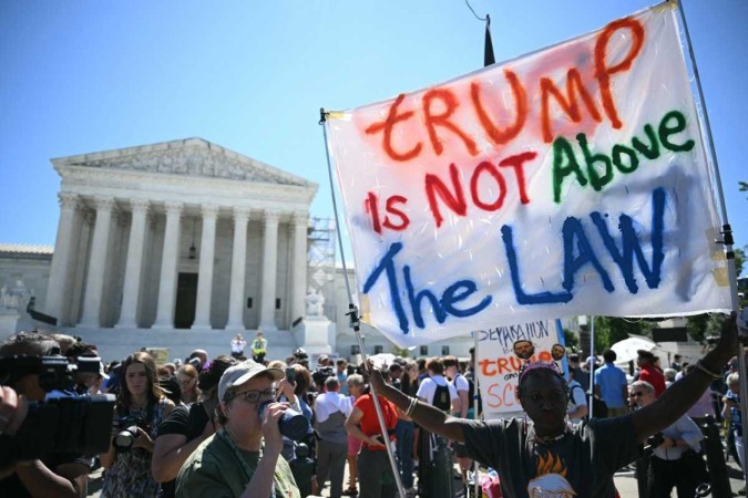 Ativistas protestam em frente ao prédio da Suprema Corte em Washington e exibem uma faixa com os dizeres 