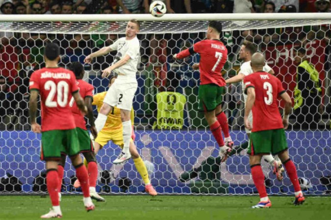  Portugal's forward #07 Cristiano Ronaldo heads the ball past Slovenia's defender #02 Zan Karnicnik during the UEFA Euro 2024 round of 16 football match between Portugal and Slovenia at the Frankfurt Arena in Frankfurt am Main on July 1, 2024. (Photo by Angelos Tzortzinis / AFP)
     -  (crédito:  AFP via Getty Images)