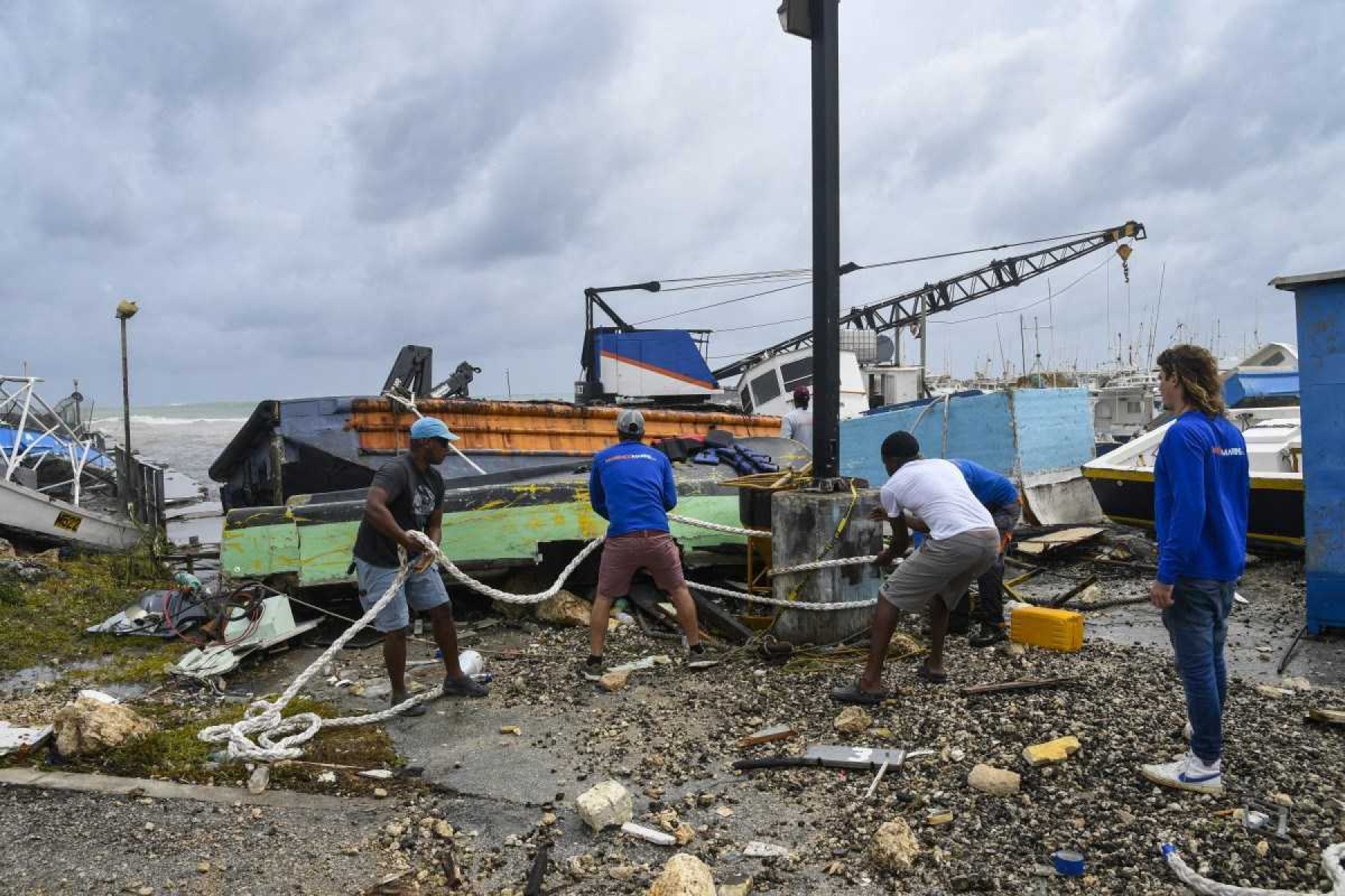    Pescadores tentam resgatar um barco de pesca danificado após a passagem do furacão Beryl no mercado de peixe de Bridgetown, Bridgetown, Barbados, 1º de julho de 2024. (Foto de Randy Brooks / AFP)       