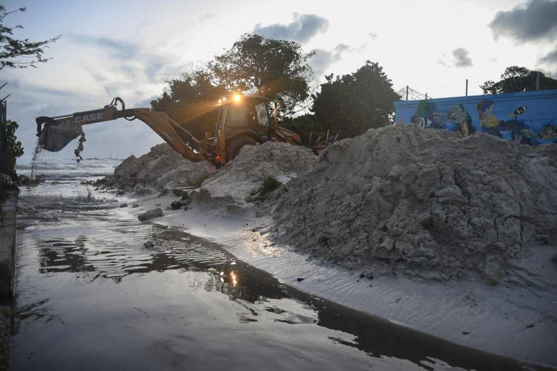     Funcionários do Ministério dos Transportes, Obras e Infraestrutura removem areia do ralo após a passagem do furacão Beryl nos jardins de Oistins, Christ Church, Barbados, em 1º de julho de 2024. (Foto de Randy Brooks / AFP)       