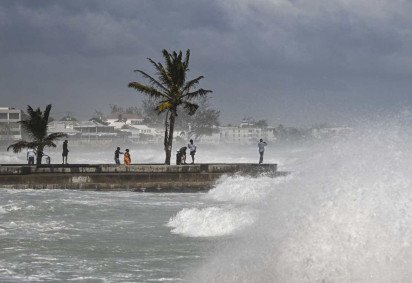 Pessoas visitam um cais durante a maré alta após a passagem do furacão Beryl em Oistins, perto de Bridgetown, Barbados, em 1º de julho de 2024       -  (crédito: CHANDAN KHANNA / AFP)
