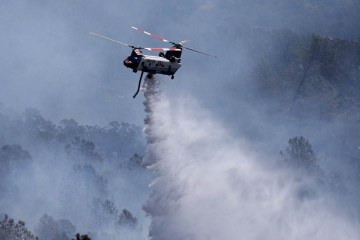  OROVILLE, CALIFORNIA - JULY 03: A firefighting helicopter drops water on the Thompson Fire on July 03, 2024 in Oroville, California. At least 12,000 Butte County residents have been evacuated as they flee the Thompson Fire that has burned more than 3,000 acres and destroyed multiple homes since starting on Monday. The fire is zero percent contained.   Justin Sullivan/Getty Images/AFP (Photo by JUSTIN SULLIVAN / GETTY IMAGES NORTH AMERICA / Getty Images via AFP)
       -  (crédito: JUSTIN SULLIVAN / GETTY IMAGES NORTH AMERICA / Getty Images via AFP)