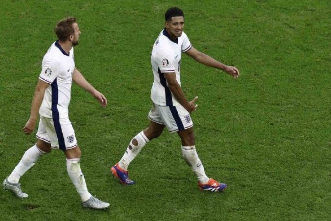 England's midfielder #10 Jude Bellingham celebrates scoring his team's first goal with England's forward #09 Harry Kane during the UEFA Euro 2024 round of 16 football match between England and Slovakia at the Arena AufSchalke in Gelsenkirchen on June 30, 2024. (Photo by KENZO TRIBOUILLARD / AFP) (Photo by KENZO TRIBOUILLARD/AFP via Getty Images)
- (crédito: AFP via Getty Images) England's midfielder #10 Jude Bellingham celebrates scoring his team's first goal with England's forward #09 Harry Kane during the UEFA Euro 2024 round of 16 football match between England and Slovakia at the Arena AufSchalke in Gelsenkirchen on June 30, 2024. (Photo by KENZO TRIBOUILLARD / AFP) (Photo by KENZO TRIBOUILLARD/AFP via Getty Images)
- (crédito: AFP via Getty Images)