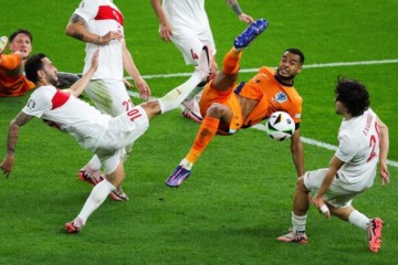 Atacante da Holanda, Gakpo (de laranja) disputa a bola com Çalhanoglu, da Turquia. Foto: Ronny Hattmann/AFP via Getty Images -  (crédito: Ronny Hattmann/AFP via Getty Images)