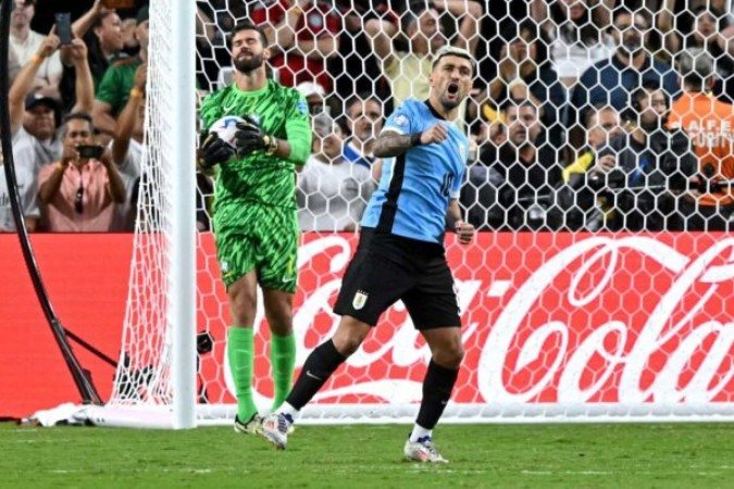 Uruguay's midfielder #10 Giorgian De Arrascaeta celebrates after scoring in a penalty shoot-out as Brazil's goalkeeper #01 Alisson reacts during the Conmebol 2024 Copa America tournament quarterfinal football match between Uruguay and Brazil at Allegiant Stadium in Las Vegas, Nevada on July 6, 2024. (Photo by Frederic J. Brown / AFP) (Photo by FREDERIC J. BROWN/AFP via Getty Images)
- (crédito: AFP via Getty Images) Uruguay's midfielder #10 Giorgian De Arrascaeta celebrates after scoring in a penalty shoot-out as Brazil's goalkeeper #01 Alisson reacts during the Conmebol 2024 Copa America tournament quarterfinal football match between Uruguay and Brazil at Allegiant Stadium in Las Vegas, Nevada on July 6, 2024. (Photo by Frederic J. Brown / AFP) (Photo by FREDERIC J. BROWN/AFP via Getty Images)
- (crédito: AFP via Getty Images)