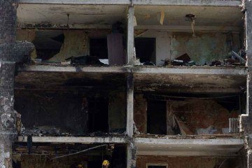 Socorristas vistoriam apartamentos em prédio destruído por míssil lançado pela Rússia em Kiev 
 -  (crédito: Anatolii Stepanov/AFP)