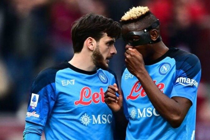  Napoli's Nigerian forward Victor Osimhen (R) talks to Napoli's Georgian forward Khvicha Kvaratskhelia during the Italian Serie A football match between Torino and Napoli on March 19, 2023 at the Olympic stadium in Turin. (Photo by Marco BERTORELLO / AFP) (Photo by MARCO BERTORELLO/AFP via Getty Images)
       -  (crédito:  AFP via Getty Images)