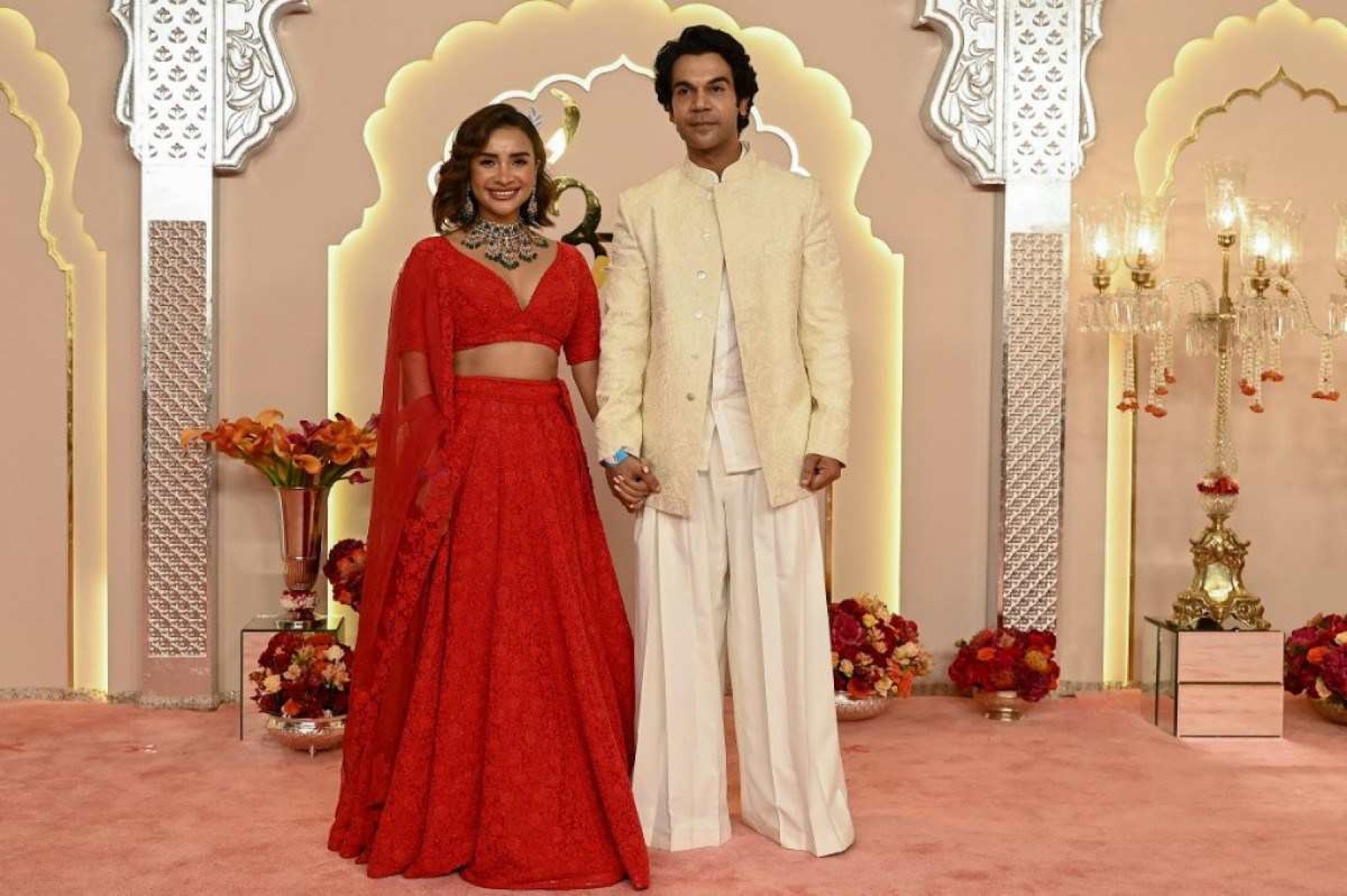 O ator de Bollywood Rajkummar Rao e sua esposa Patralekha (L) posam para fotos ao chegarem para participar da cerimônia de casamento do magnata bilionário