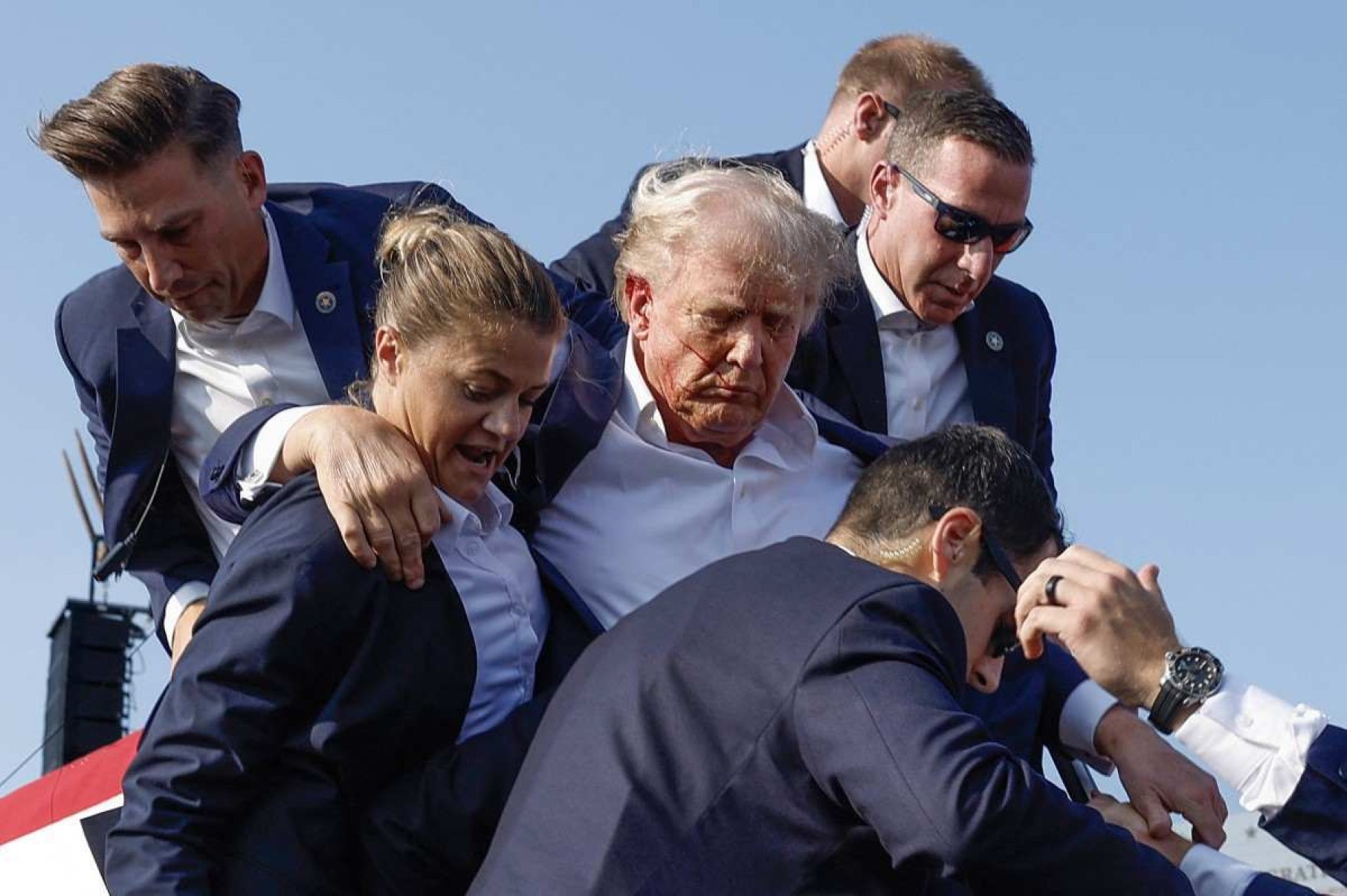  BUTLER, PENNSYLVANIA - JULY 13: Republican presidential candidate former President Donald Trump is rushed offstage by U.S. Secret Service agents after being grazed by a bullet during a rally on July 13, 2024 in Butler, Pennsylvania.   Anna Moneymaker/Getty Images/AFP (Photo by Anna Moneymaker / GETTY IMAGES NORTH AMERICA / Getty Images via AFP)       