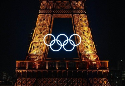 Esta fotografia mostra os anéis olímpicos na Torre Eiffel antes dos tradicionais fogos de artifício que marcam o Dia anual da Bastilha em Paris, em 14 de julho de 2024. -  (crédito: Dimitar DILKOFF / AFP)