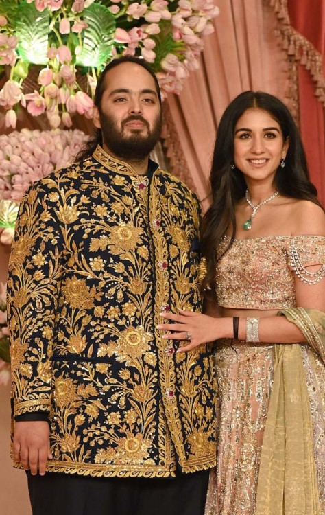  (FILES) Radhika Merchant (R) with his fiancé Anant Ambani, son of billionaire Mukesh Ambani (unseen) pose for a picture during their sangeet ceremony in Mumbai on July 5, 2024. Asia's richest man, Mukesh Ambani, spent the last two decades transforming the stodgy petrochemicals giant he inherited into a global empire spanning telecoms, retail, cricket and luxury fashion. His youngest son Anant marries childhood sweetheart Radhika Merchant in a lavish three-day wedding in Mumbai beginning July 12, an opportunity for the tycoon to showcase his place at the top of India's corporate hierarchy. (Photo by SUJIT JAISWAL / AFP)
       -  (crédito: SUJIT JAISWAL / AFP)