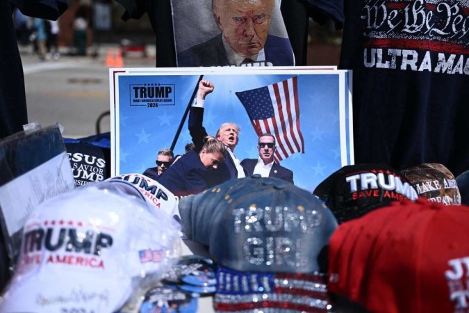 Bonés e uma foto de Trump ferido após o ataque de sábado são vendidos em frente ao Firserv Forum, onde acontece a Convenção Nacional Republicana, em Milwaukee (Wisconsin)