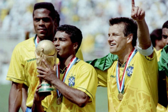  Brazilian forward Romario kisses the FIFA World Cup trophy, flanked by Ronaldao (L) and captain Dunga, after Brazil defeated Italy 3-2 in the shoot-out session (0-0 after extra time) at the end of the World Cup final, 17 July 1994 at the Rose Bowl in Pasadena. Italian Roberto Baggio missed his penalty kick to give Brazil its fourth World Cup title after 1958, 1962 and 1970.    AFP PHOTO/DANIEL GARCIA (Photo by DANIEL GARCIA / AFP)
     -  (crédito:  AFP via Getty Images)