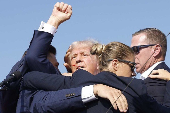  BUTLER, PENNSYLVANIA - JULY 13: Republican presidential candidate former President Donald Trump is rushed offstage by U.S. Secret Service agents after being grazed by a bullet during a rally on July 13, 2024 in Butler, Pennsylvania. Butler County district attorney Richard Goldinger said the shooter is dead after injuring former U.S. President Donald Trump, killing one audience member and injuring another in the shooting.   Anna Moneymaker/Getty Images/AFP (Photo by Anna Moneymaker / GETTY IMAGES NORTH AMERICA / Getty Images via AFP)
      