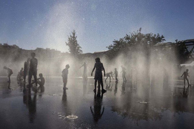 Pausa para o refresco em uma fonte de Madri, na Espanha: termômetros vão baixar, mas ainda haverá oscilações nas próximas semanas 
 -  (crédito:  AFP)