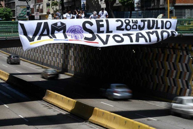  Students place a banner in support of Venezuelan presidential candidate Edmundo Gonzalez Urrutia in Caracas on July 24, 2024, ahead of Sunday's presidential election. Venezuela's President Nicolas Maduro will seek a third consecutive six-year term in July 28 elections -- against a severely weakened political opposition in what critics call a campaign of relentless persecution. (Photo by Federico PARRA / AFP)
      