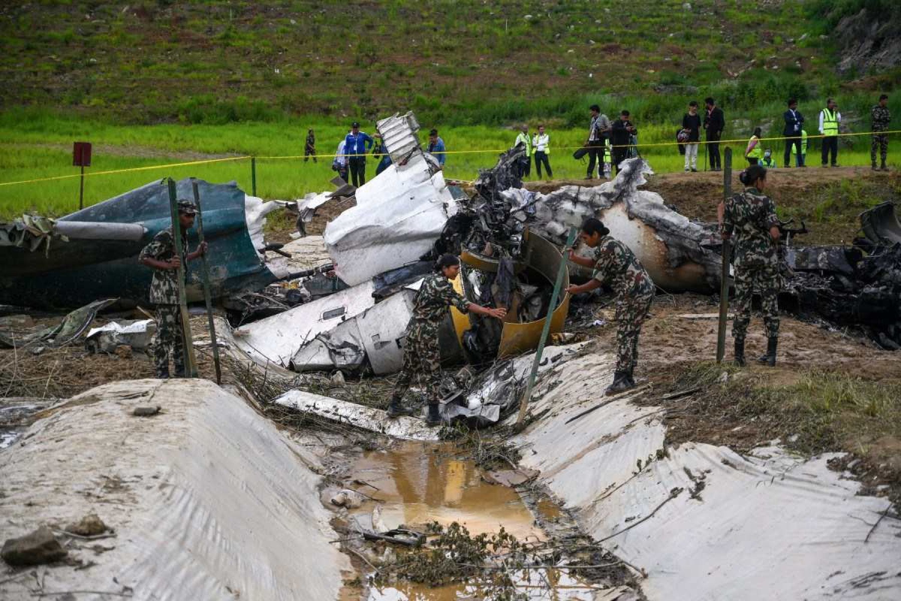 O pessoal do exército remove os destroços de um avião da Saurya Airlines depois que ele caiu durante a decolagem no Aeroporto Internacional de Tribhuvan em Katmandu em 24 de julho de 2024      