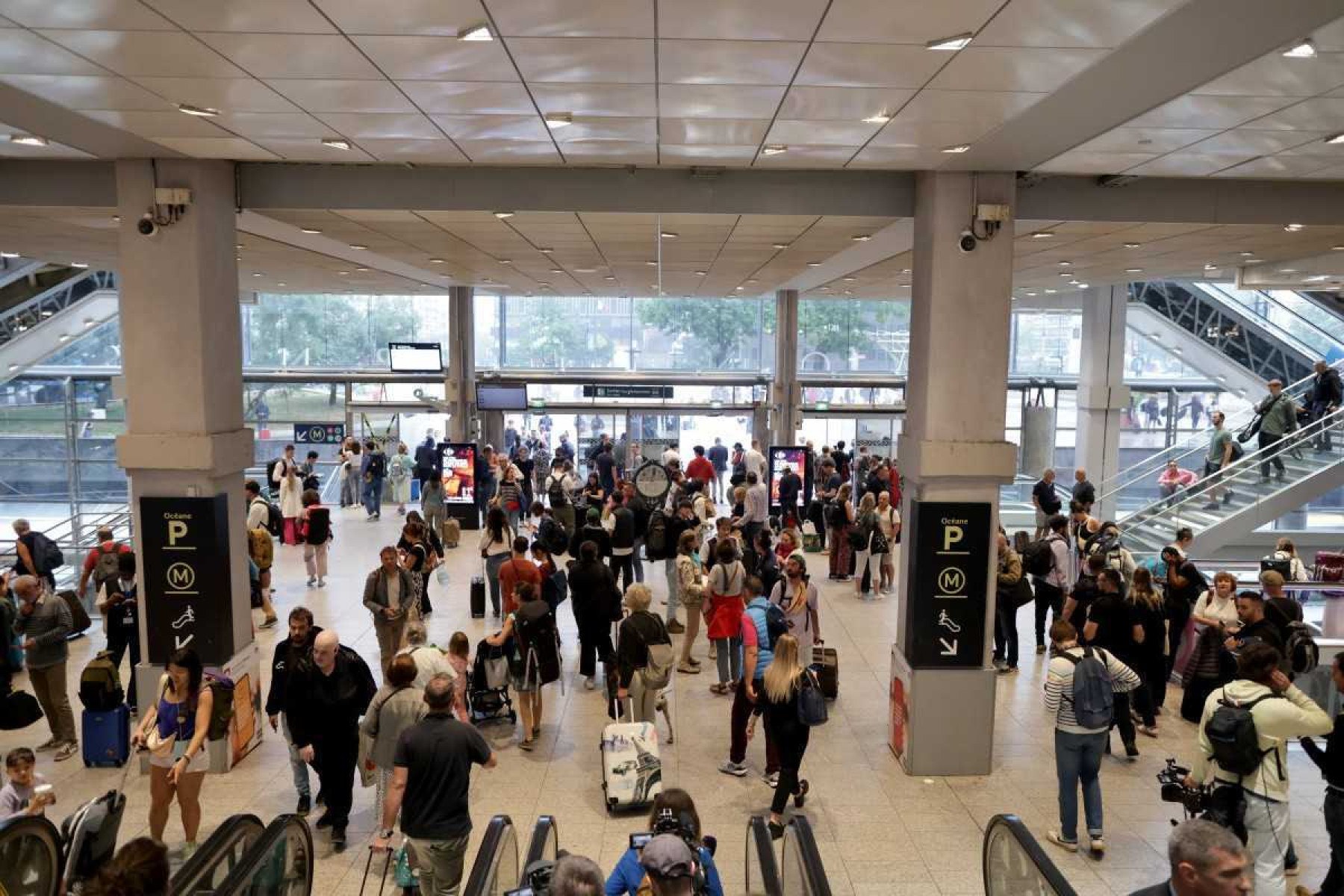     Passageiros vagam na estação ferroviária Gare Montparnasse, em Paris, em 26 de julho de 2024, enquanto a rede ferroviária de alta velocidade da França era atingida por atos maliciosos que perturbavam o sistema de transporte horas antes da cerimônia de abertura dos Jogos Olímpicos de Paris 2024.  Segundo a SNCF, um ataque massivo em grande escala atingiu a rede TGV e muitas rotas terão de ser canceladas.  A SNCF instou os passageiros a adiarem as suas viagens e a ficarem longe das estações ferroviárias.  (Foto de Thibaud MORITZ/AFP)
      