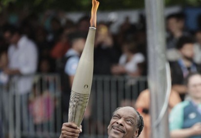 O rapper norte-americano Snoop Dogg segura a tocha no Revezamento da Tocha dos Jogos Olímpicos de Paris 2024, no dia da cerimônia de abertura       -  (crédito: STEPHANE DE SAKUTIN / AFP)