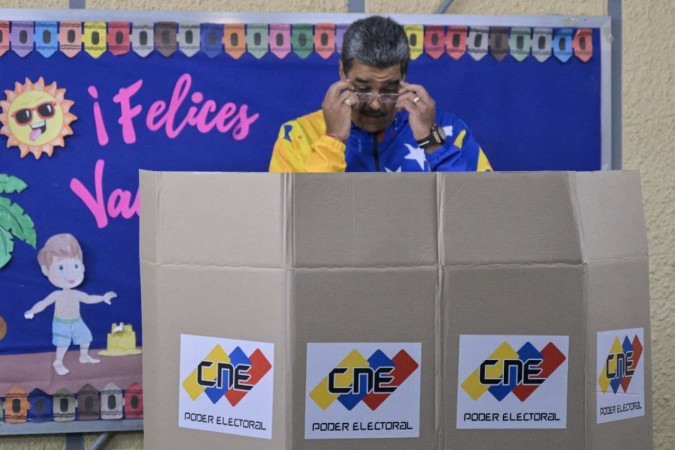  Venezuelan President and presidential candidate Nicolas Maduro adjusts his pair of glasses as he votes during the presidential election, in Caracas on July 28, 2024. Voters in Venezuela began their ballots in the midst of political unpredictability, with incumbent Nicolas Maduro, who seeks a third six-year term, vowing a 