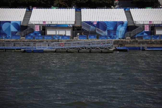 Imagem mostra arquibancadas vazias às margens do rio Sena após cancelamento de um treino de triatlo. -  (crédito: Valentine CHAPUIS/AFP)