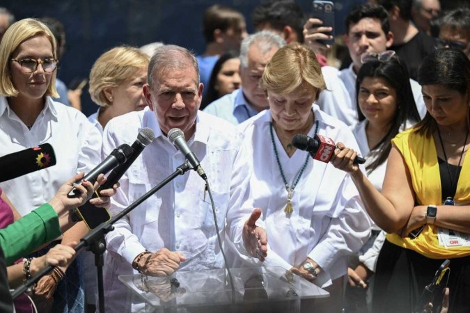 Edmundo González Urrutia (C) discursa ao lado da mulher, Mercedes López (D), e da filha Mariana, em Caracas -  (crédito: Raul Arboleda/AFP)