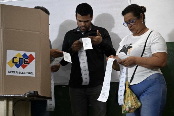  Election staffers count votes after polling stations closed during the presidential election, in Caracas on July 28, 2024. Venezuelans vote Sunday between continuity in President Nicolas Maduro or change in rival Edmundo Gonzalez Urrutia amid high tension following the incumbent's threat of a 