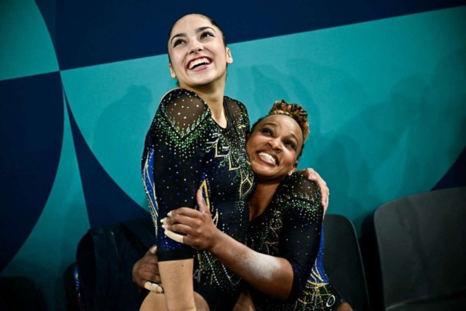 A brasileira Rebeca Andrade (R) comemora com a brasileira Julia Soares durante a qualificação feminina de ginástica artística nos Jogos Olímpicos Paris 2024 -  (crédito: Loic VENANCE / AFP)